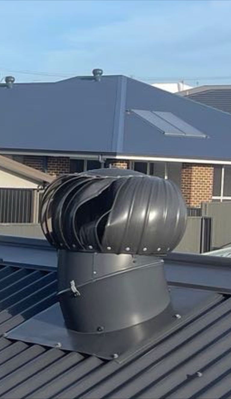 Dented whirlybird on a Colorbond metal roof, with the gutter and barge capping visible along the roof edge